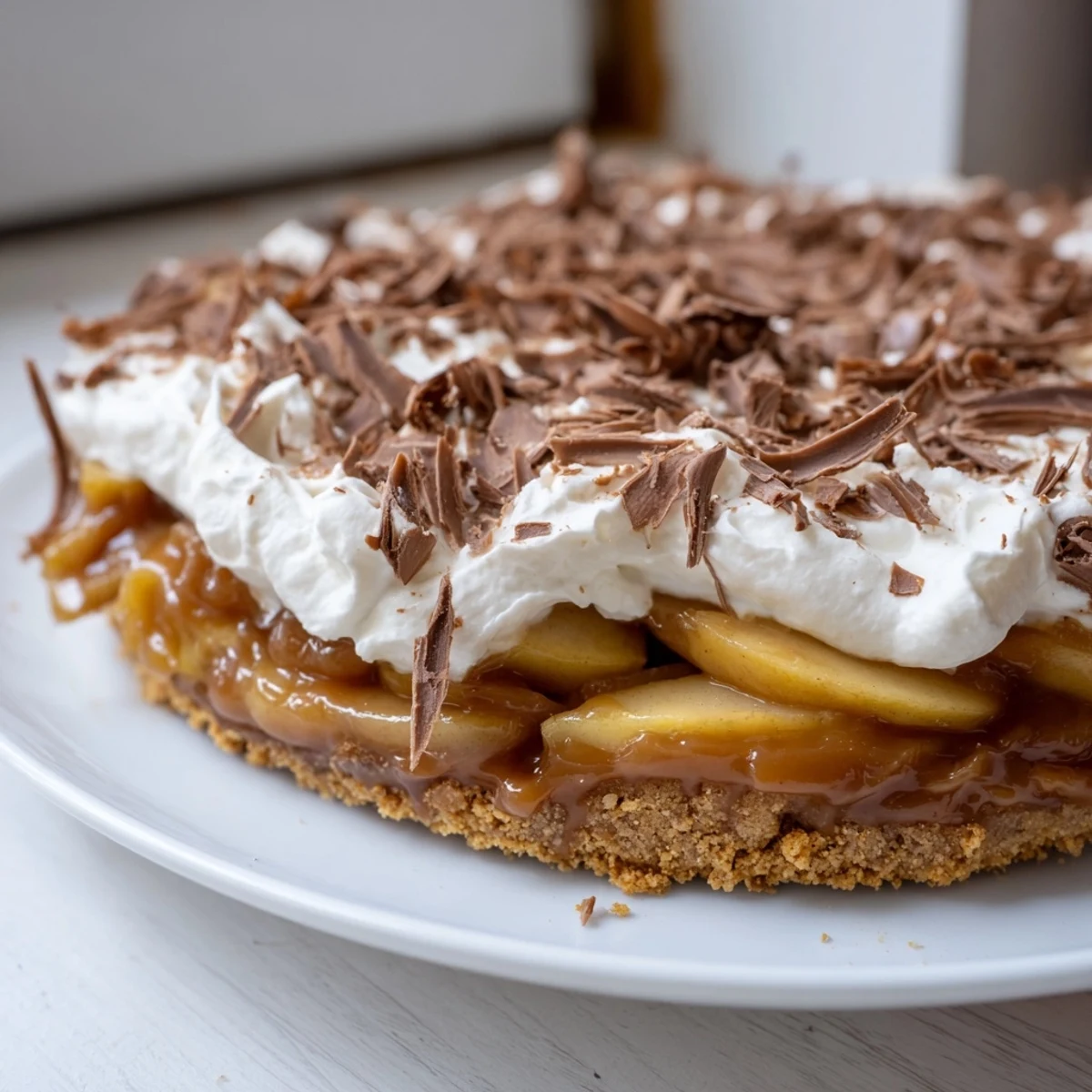 Luscious caramel apple banoffee pie topped with whipped cream and chocolate shavings.  