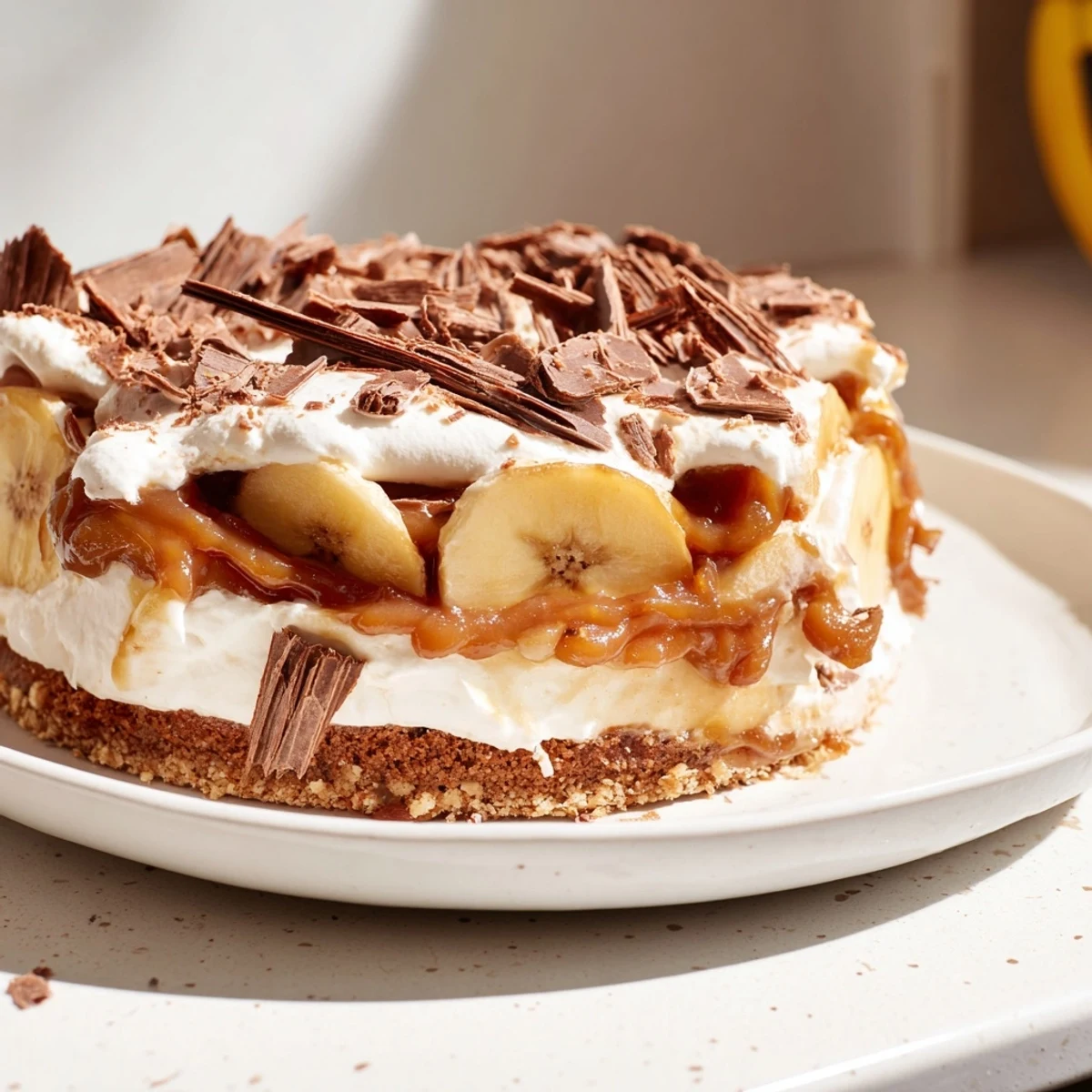 Sliced caramel apple banoffee pie served with a drizzle of rich caramel sauce.