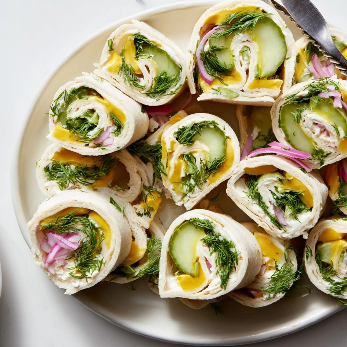 Tangy pickle-in-a-blanket bites, ideal for picnics, featuring soft tortillas and cheese.