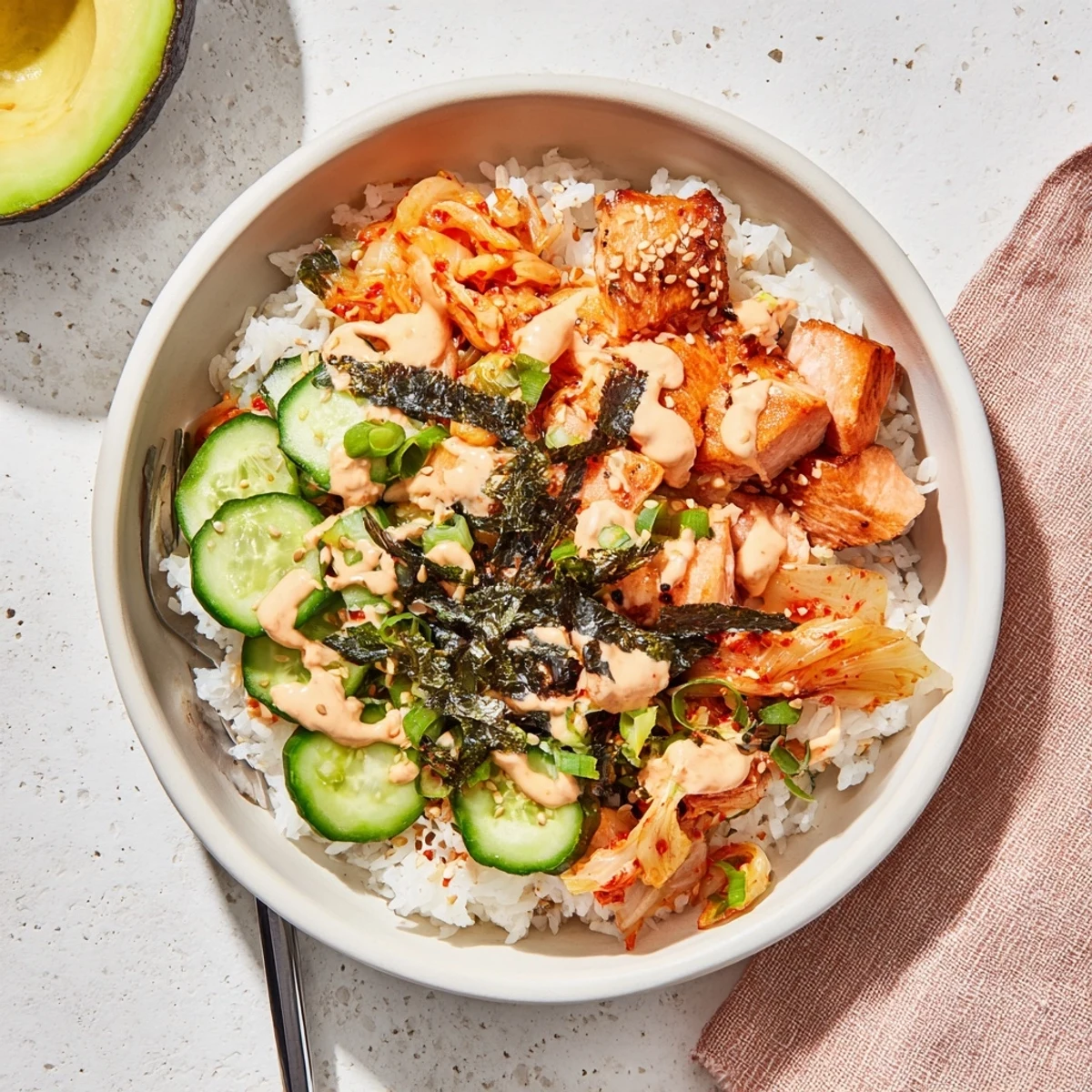 Crispy Salmon Rice Bowl with avocado, kimchi, and spicy mayo drizzled on top.  