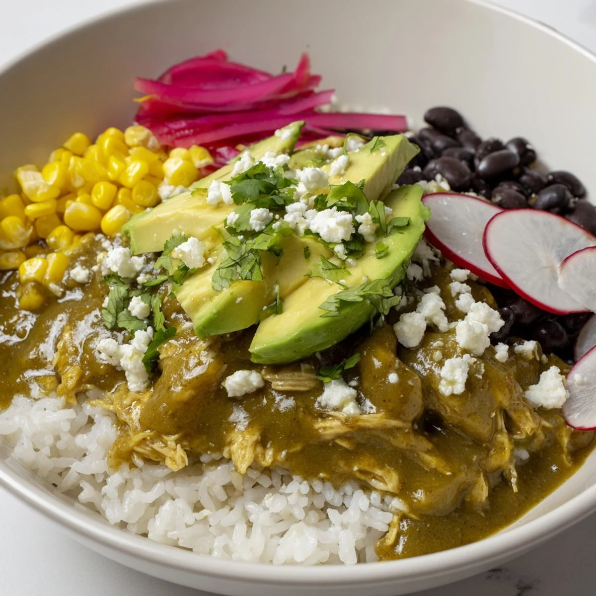 Enjoy a steaming bowl of Green Enchilada Rice Bowl, complete with cool avocado and a squeeze of lime.