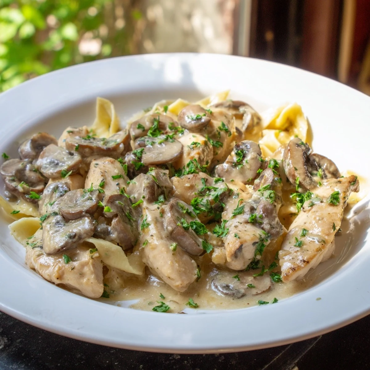 Fresh parsley garnish topping a steaming plate of Creamy Chicken Stroganoff, ready to be enjoyed.