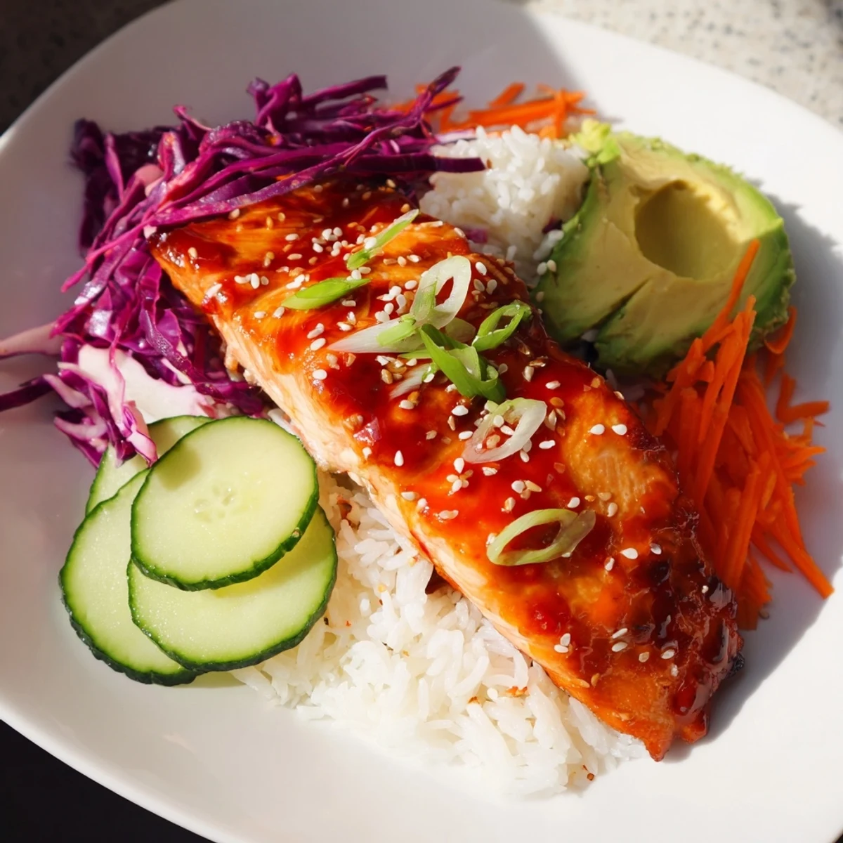 A perfectly plated sweet chili salmon rice bowl, showcasing tender salmon and fresh veggies.