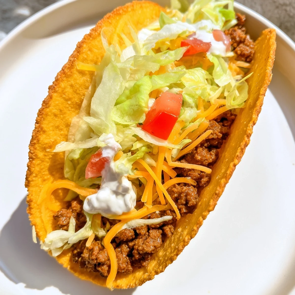 Golden, cheesy Gordita Crunch tacos with seasoned beef, lettuce, and creamy sauce, ready to eat.
