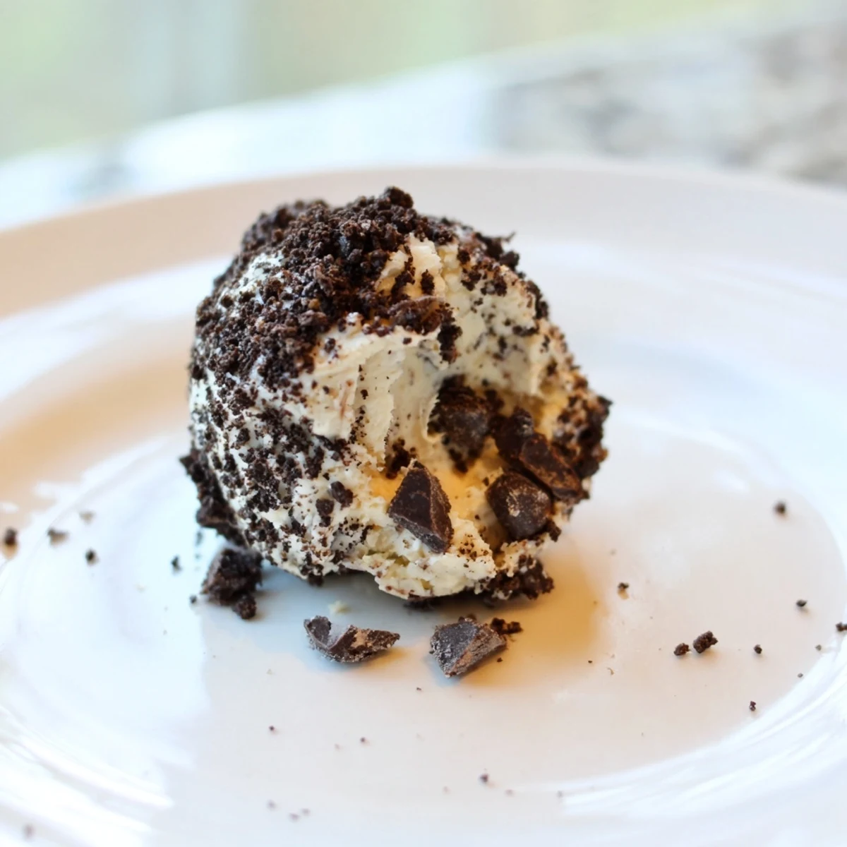 Cream cheese Oreo protein balls, a no-bake treat with a creamy texture and cookie pieces.