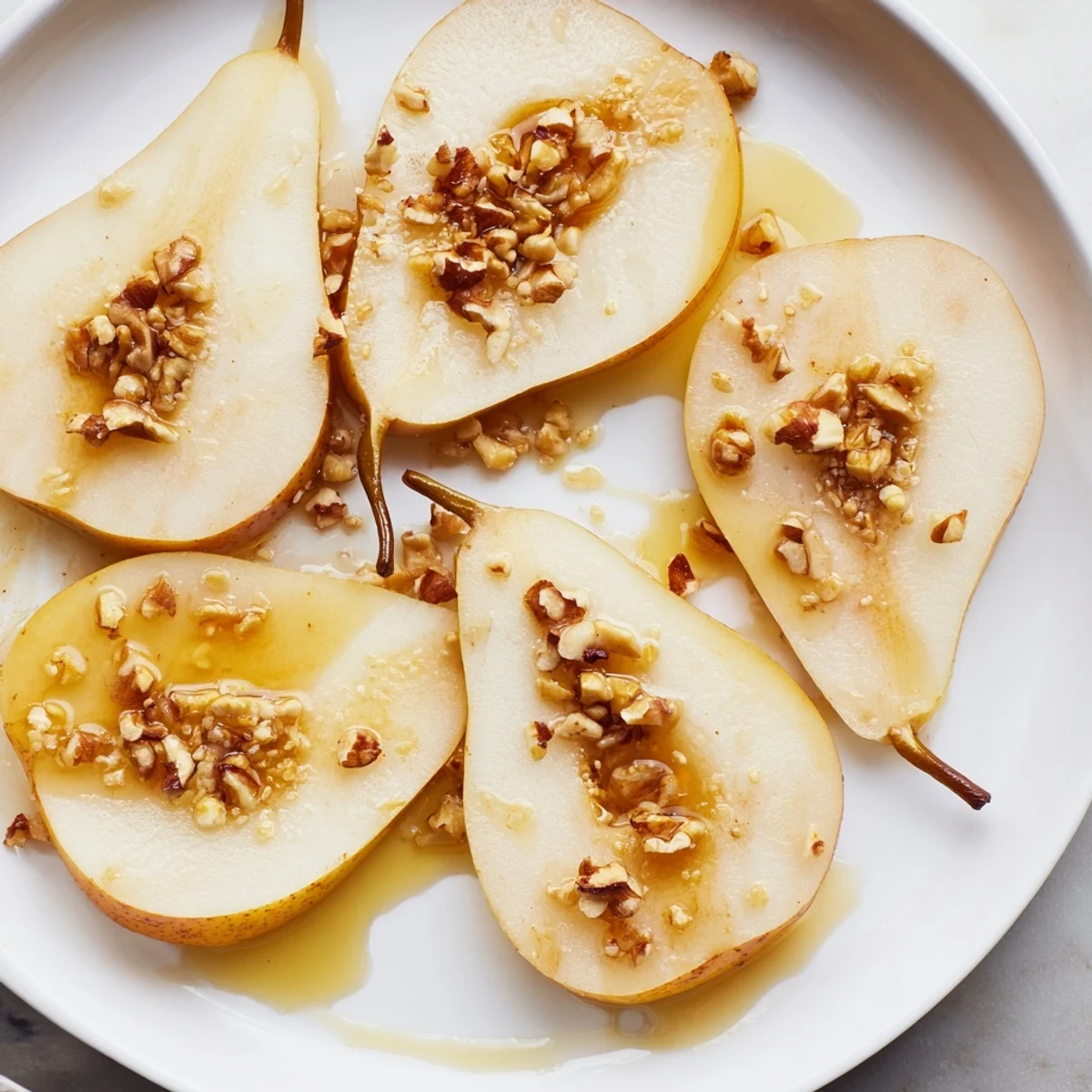 Fresh pear slices, glistening with honey drizzle, ready for a delightful and simple snack.