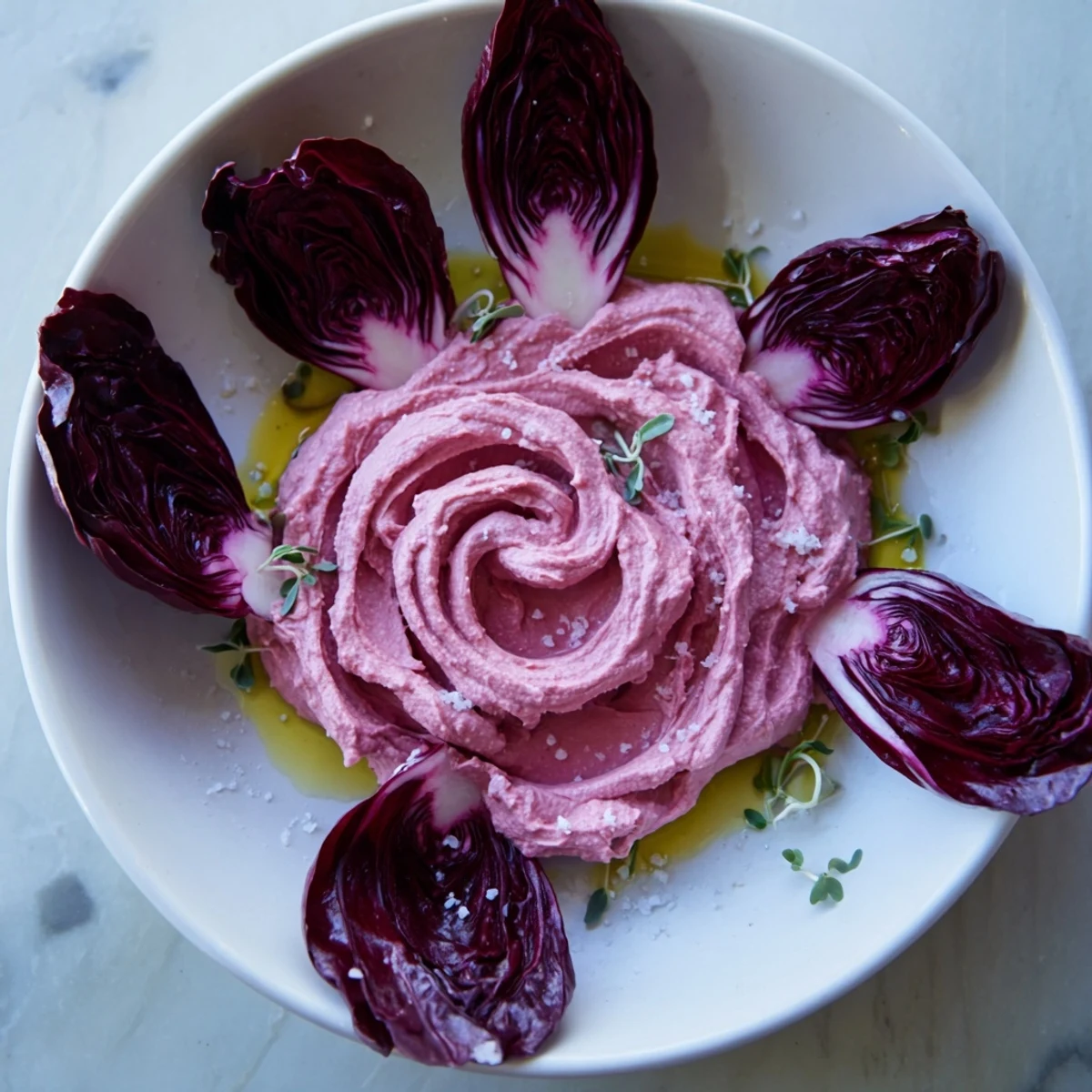 Close-up of The Velvet Rose appetizer: beautiful dark red beet hummus roses with crisp greens, ready to eat.