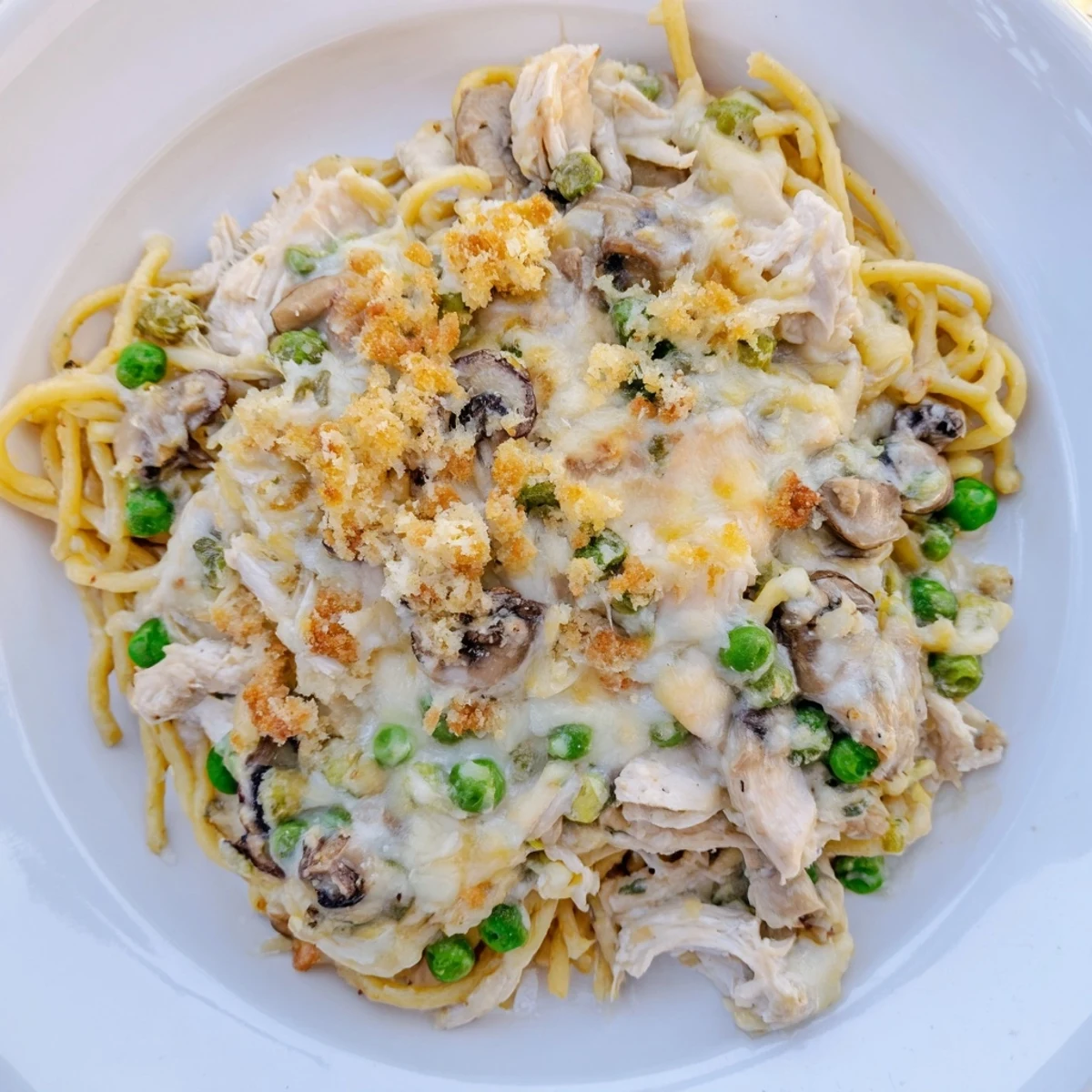 A close-up shot of a bubbly Turkey Tetrazzini, showing a delicious, comforting baked dinner.