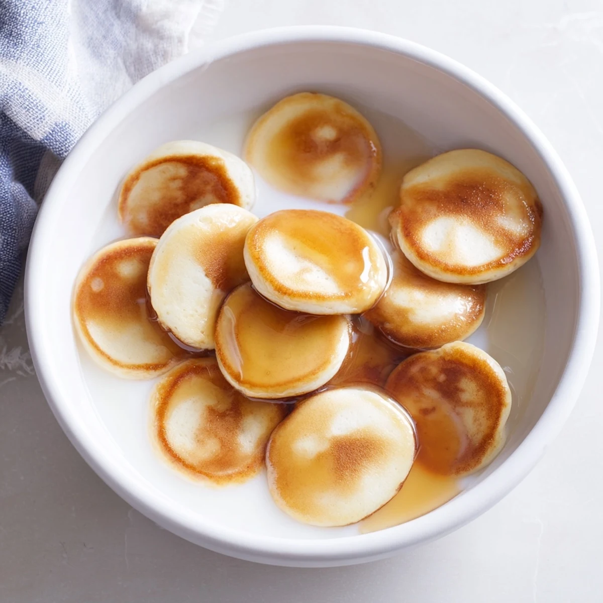Fluffy pancake cereal served in a bowl, golden brown and ready to be enjoyed with milk and syrup.