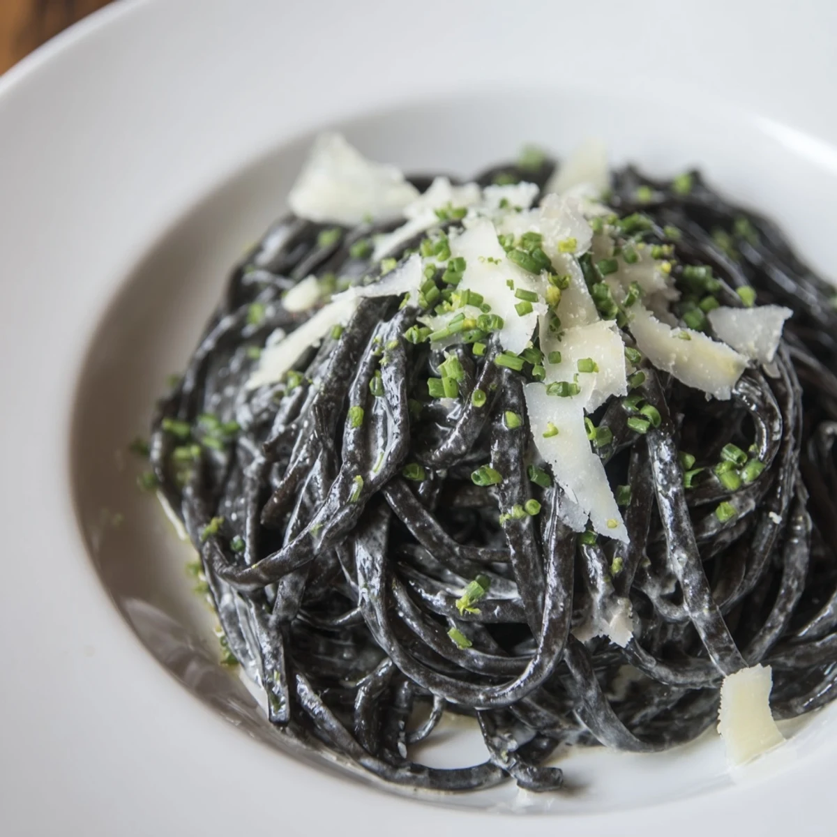 A beautiful swirl of dramatic squid ink pasta coated in a luxurious, creamy sauce with Parmesan.