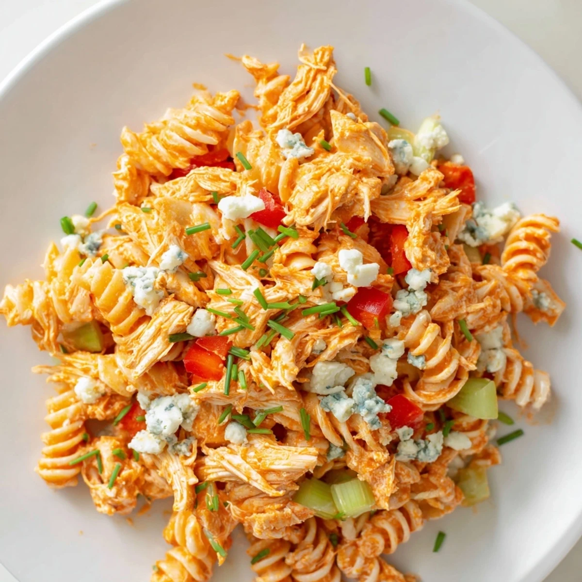 Cold pasta salad with spicy buffalo chicken, crunchy vegetables, and ranch dressing, perfect for a summer potluck or picnic side dish.