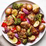 Aromatic Lazy Gourmet Chicken & Vegetable One-Pot served with fresh parsley and lemon wedges.  