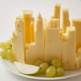 A vibrant Skyline Silhouette cheese board, featuring cheddar, Havarti, and more, ready to serve.