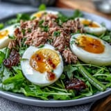 A vibrant Spring Niçoise Salad platter with cherry tomatoes, baby potatoes, olives, and oil-packed tuna, ready to serve.