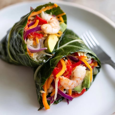 Close-up image of assembled Shrimp & Cheddar Collard Green Wraps, sliced to show filling.