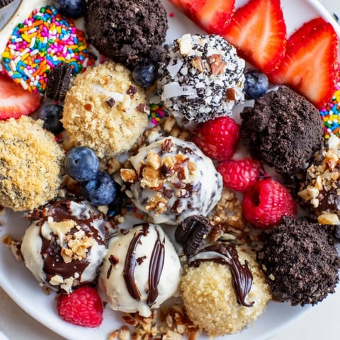 Deconstructed dessert board with cheesecake bites, topped with fresh fruits and candies.  
