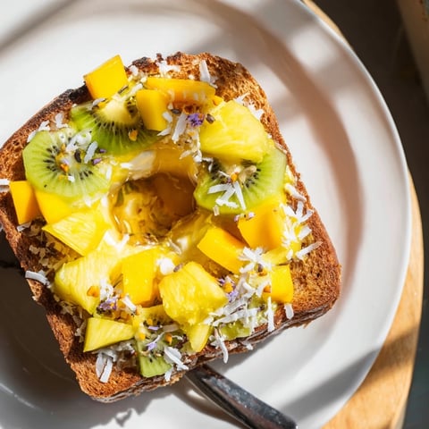 Creamy yogurt-custard toast topped with vibrant tropical fruits for a delightful breakfast.  