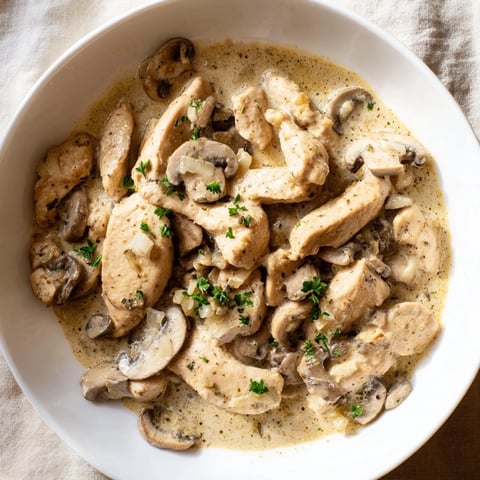 Creamy Chicken Stroganoff over egg noodles, a comforting bowl of rich, savory stew.