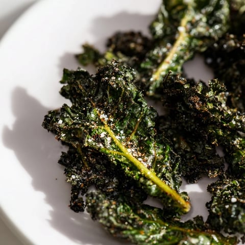 Golden-brown Baked Kale Chips, crispy and salty, ready to be enjoyed as a healthy snack.