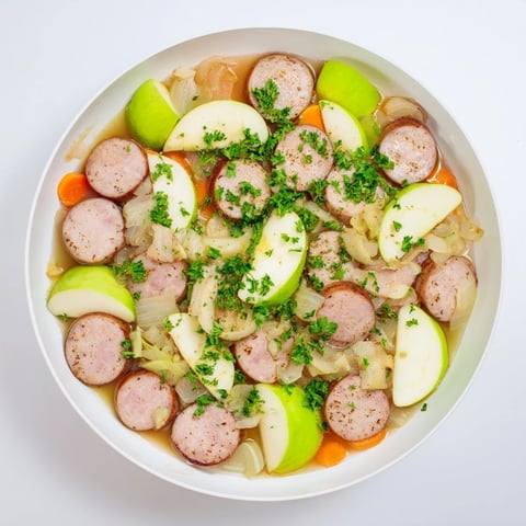 Steaming Stovetop Sausage, Celery, and Apple Hotpot with browned sausage pieces and tender vegetables.