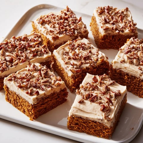Golden, frosted Pumpkin Bars with a dusting of nuts, ready for a delicious treat.