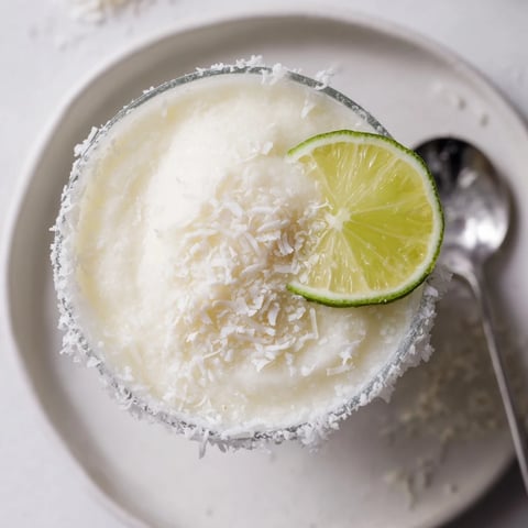 Festive White Christmas Margarita Slush, a creamy cocktail with a coconutty, lime-kissed coolness.
