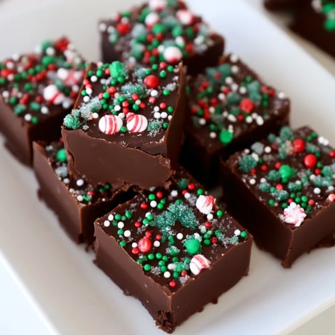 Creamy, rich 3-Ingredient Christmas Fudge Squares, sprinkled with festive red and green candies, ready to enjoy.