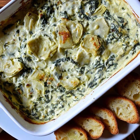 Creamy spinach artichoke dip, bubbling hot and served with crispy, golden baguette slices.