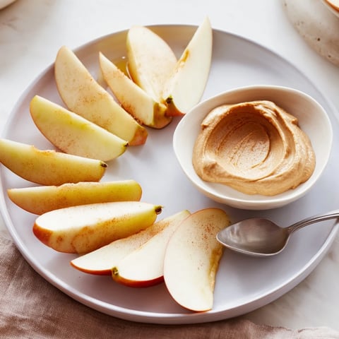 Fresh apple slices ready to dip into a creamy peanut butter dip for a quick snack.