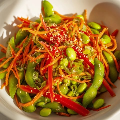 A colorful Asian Edamame Salad boasts bright green edamame and crunchy red pepper; served chilled.