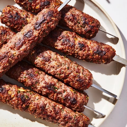 Smoky grilled Iraqi Kebab Tikka skewers, vividly presented, offering authentic Middle Eastern flavors.