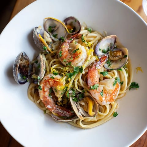 Steaming bowls of Seafood Linguine, showing plump shrimp and flavorful clams in a rich white wine sauce.