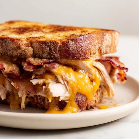 Golden, buttery sourdough is grilled to a perfect crisp, sandwiching melted cheddar, roasted turkey, and crispy bacon in this Turkey Club Grilled Cheese.