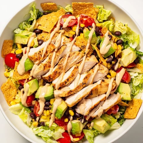 A vibrant bowl of Crunchy Taco Chicken Salad with seasoned chicken, crisp romaine, and crunchy shell pieces.