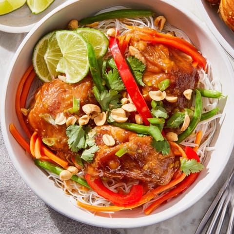 Vibrant Thai Chili Chicken Noodle Bowls shimmer, garnished with peanuts and fresh cilantro.