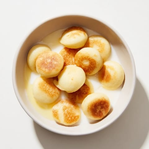 A bowl overflowing with tiny pancake cereal, ready to be enjoyed with fresh, juicy berries.