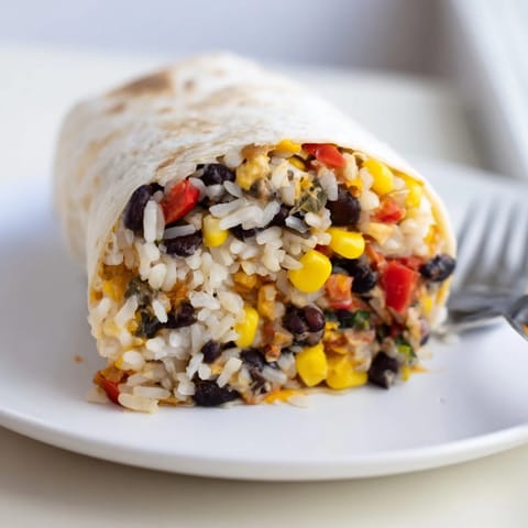 A close-up of a perfectly wrapped freezer-friendly burrito, highlighting the flavorful ingredients inside.