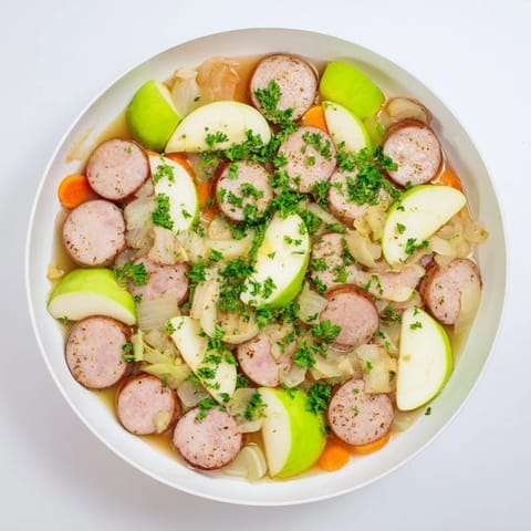 Steaming Stovetop Sausage, Celery, and Apple Hotpot with browned sausage pieces and tender vegetables.