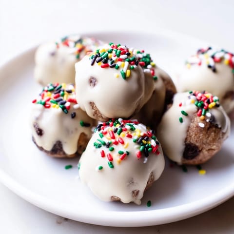 Close-up of frosted Protein-Packed Italian Christmas Cookie Balls, ready to be enjoyed with a sweet glaze and sprinkles.