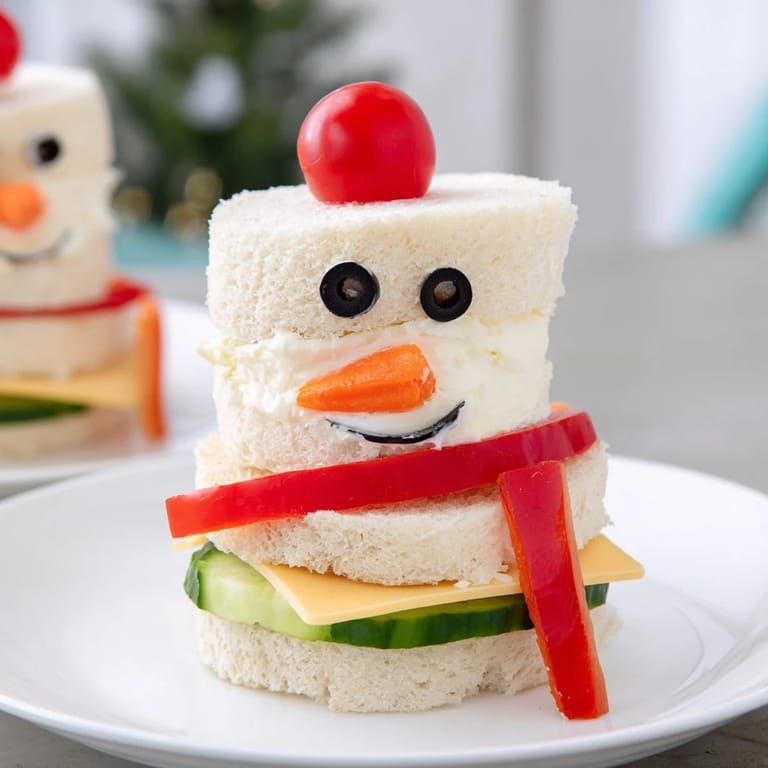 Perfect for kids, this creative Snowman Sandwich Stack shows colorful veggie details and creamy fillings.